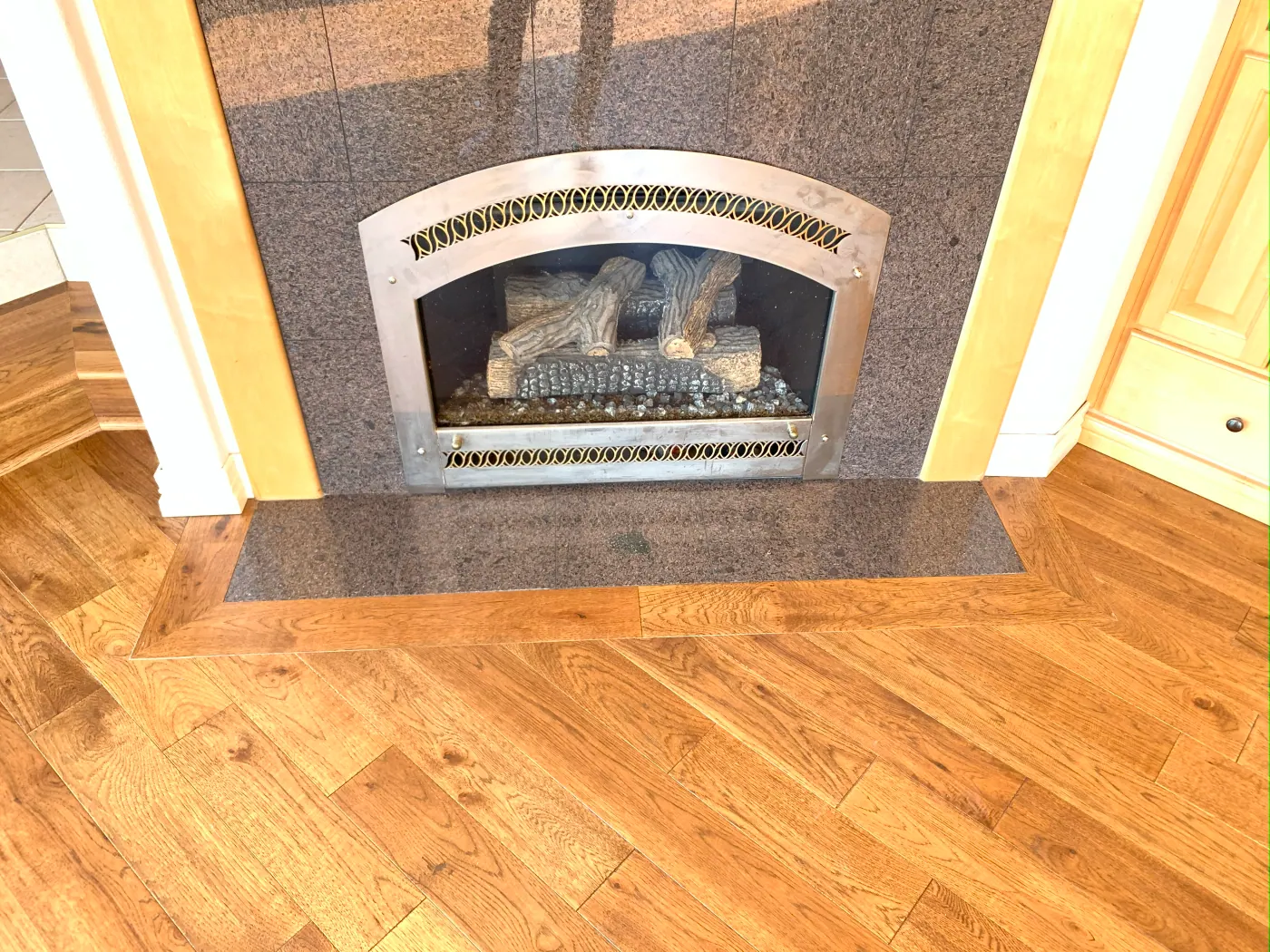 Wide oak hardwood flooring laid at an angle beside a fireplace in a Tulsa, OK living room
