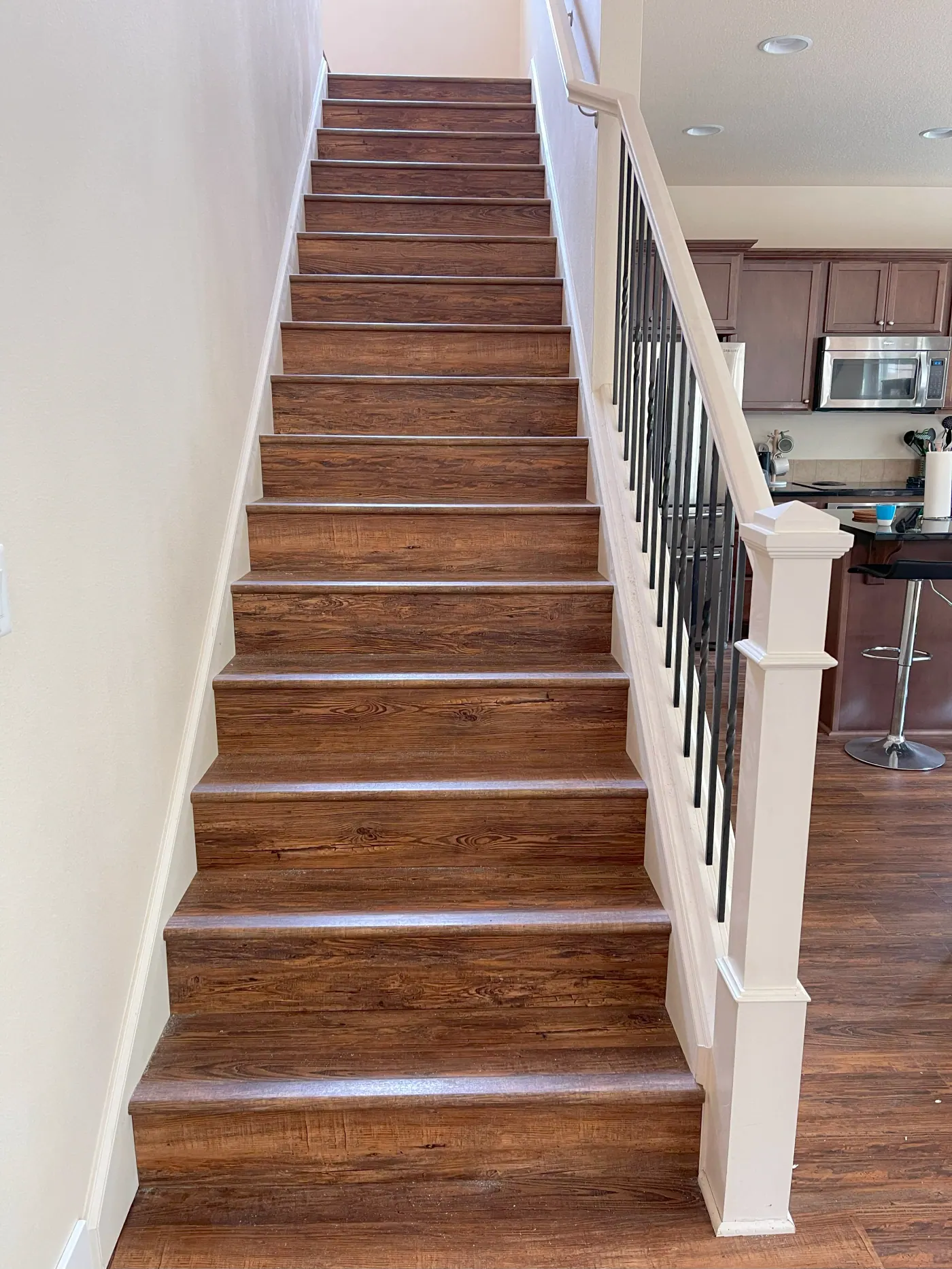 Dark stained staircase treads with black iron balusters in a Tulsa, OK home
