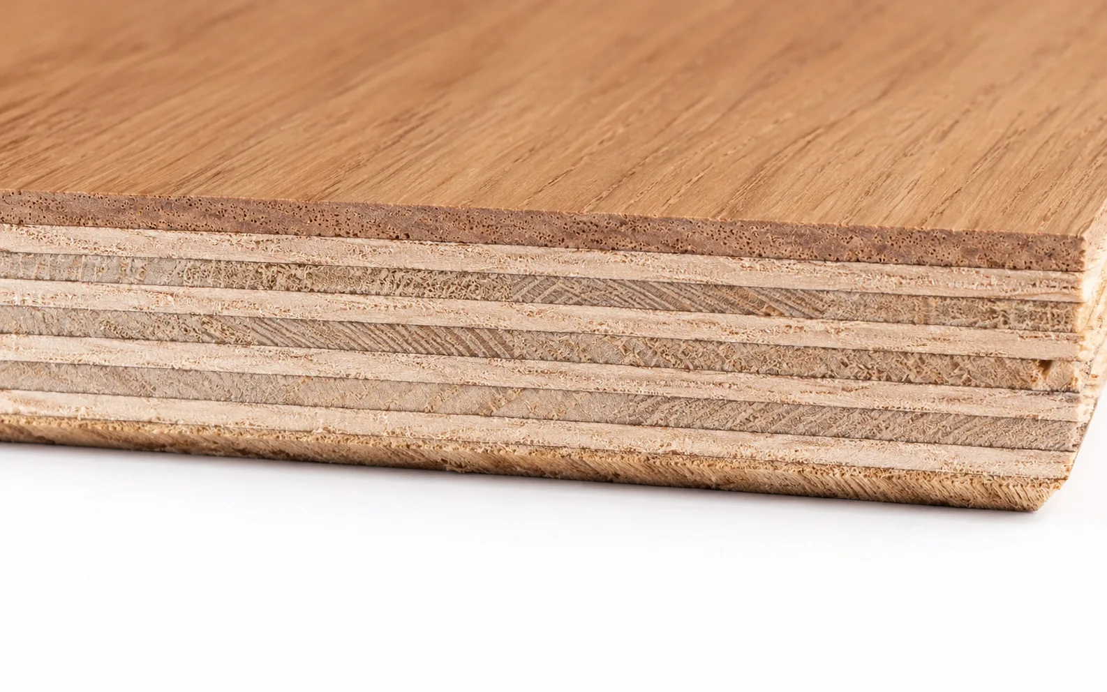 Close up of an engineered hardwood flooring plank edge showing the real oak wear layer over a cross ply core of alternating veneers