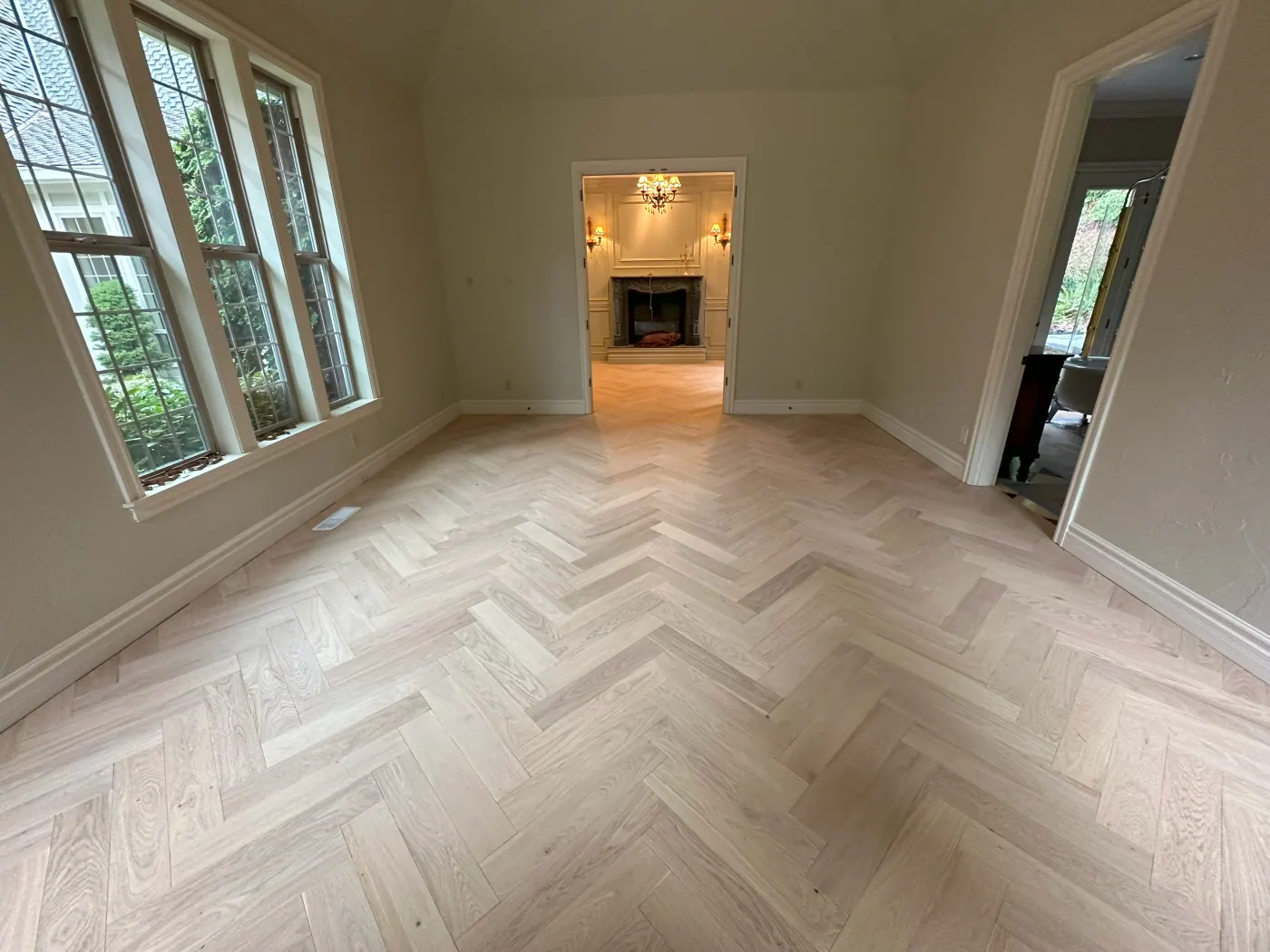 Herringbone laminate flooring in a Tulsa, OK room with a bay window