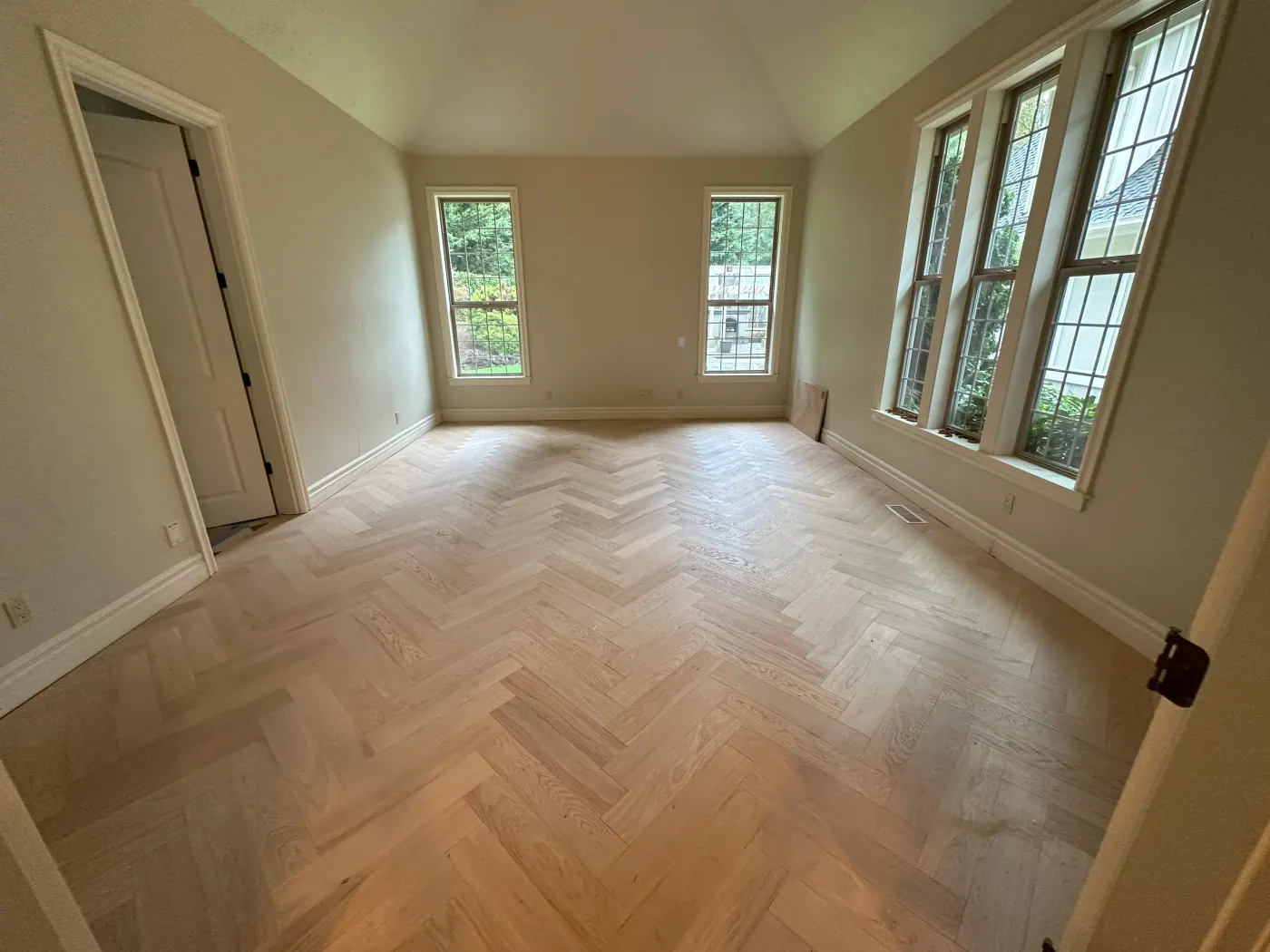 Finished herringbone plank flooring in a bright, cleaned room ready for handoff in a Tulsa, OK home