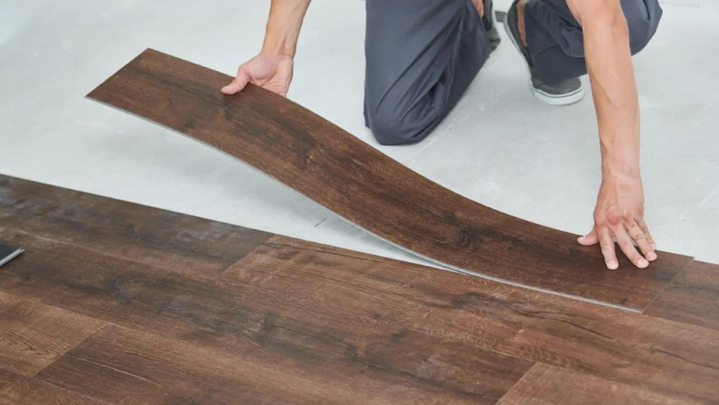 Installer laying a laminate plank during a flooring installation in Tulsa, OK