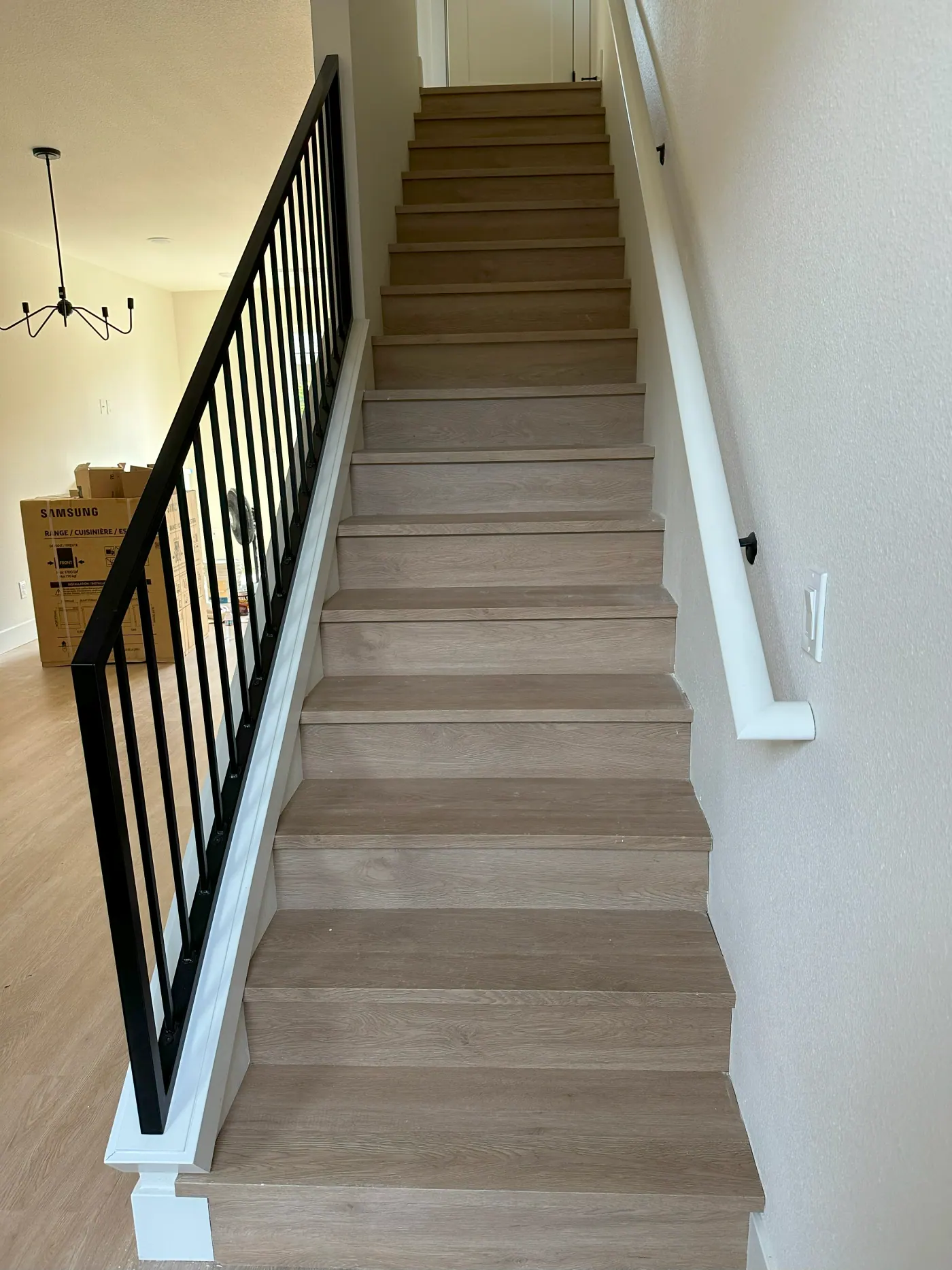 Light stair treads with a black metal railing in a Tulsa, OK home