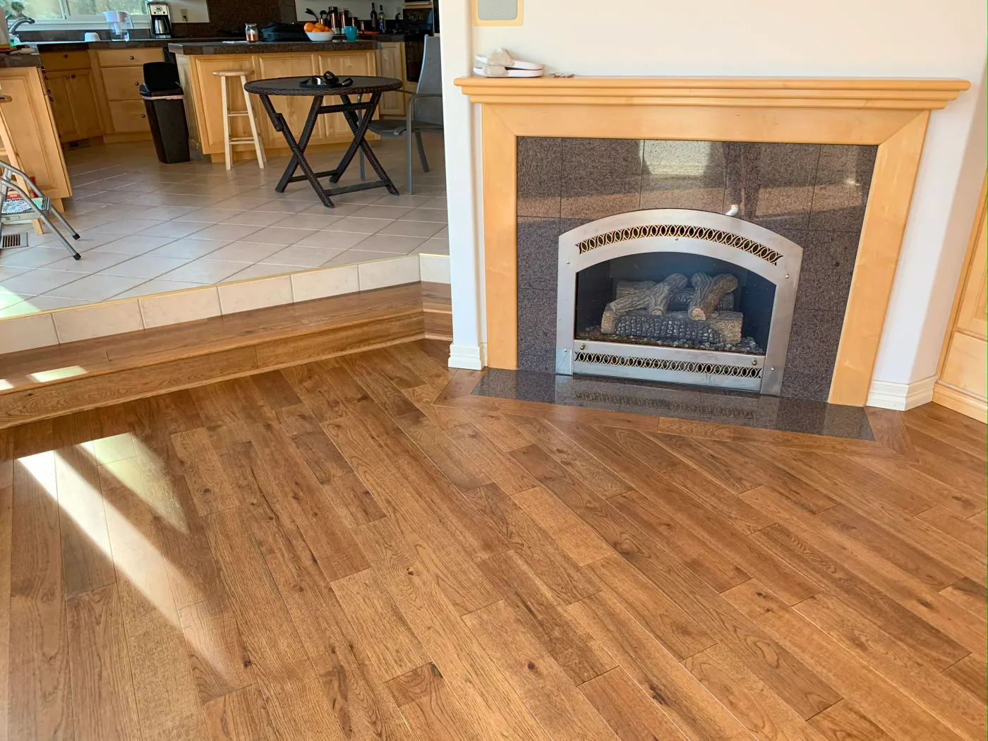 Oak hardwood flooring running from a living room fireplace through to the kitchen in a Tulsa, OK home