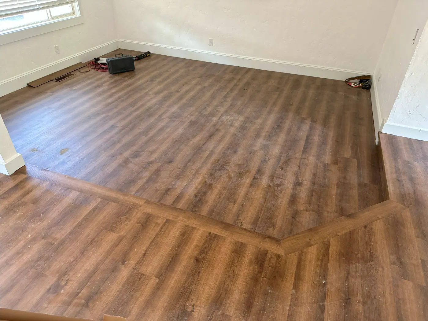 Warm toned laminate flooring finished in a Tulsa, OK living room